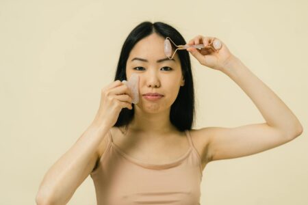Close-up of hands holding a curved facial massage tool during a skincare routine