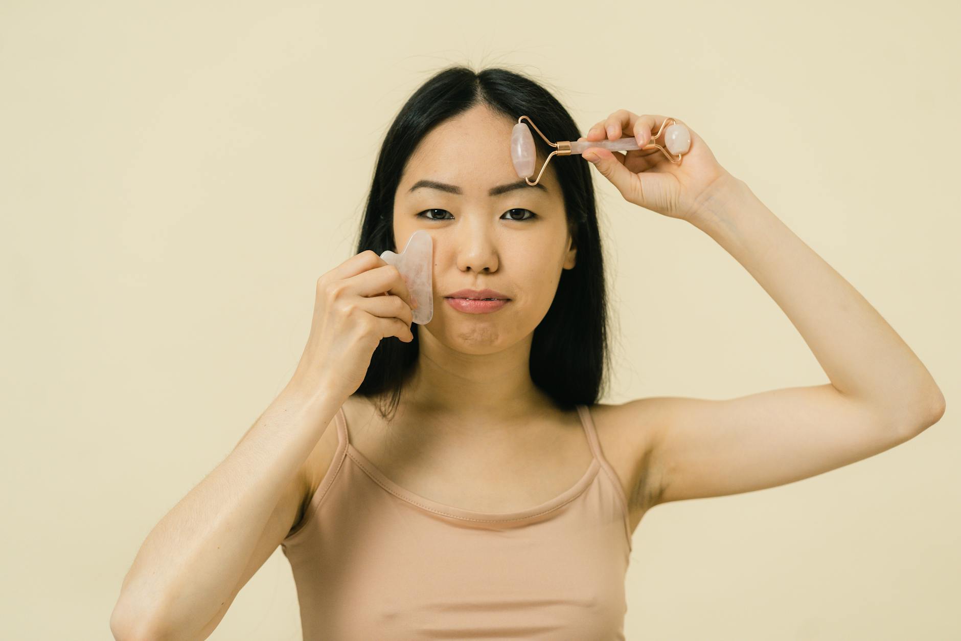 Close-up of hands holding a curved facial massage tool during a skincare routine