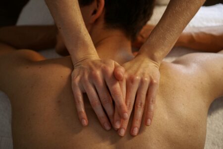 Professional massage therapist preparing treatment room with oils and therapeutic tools
