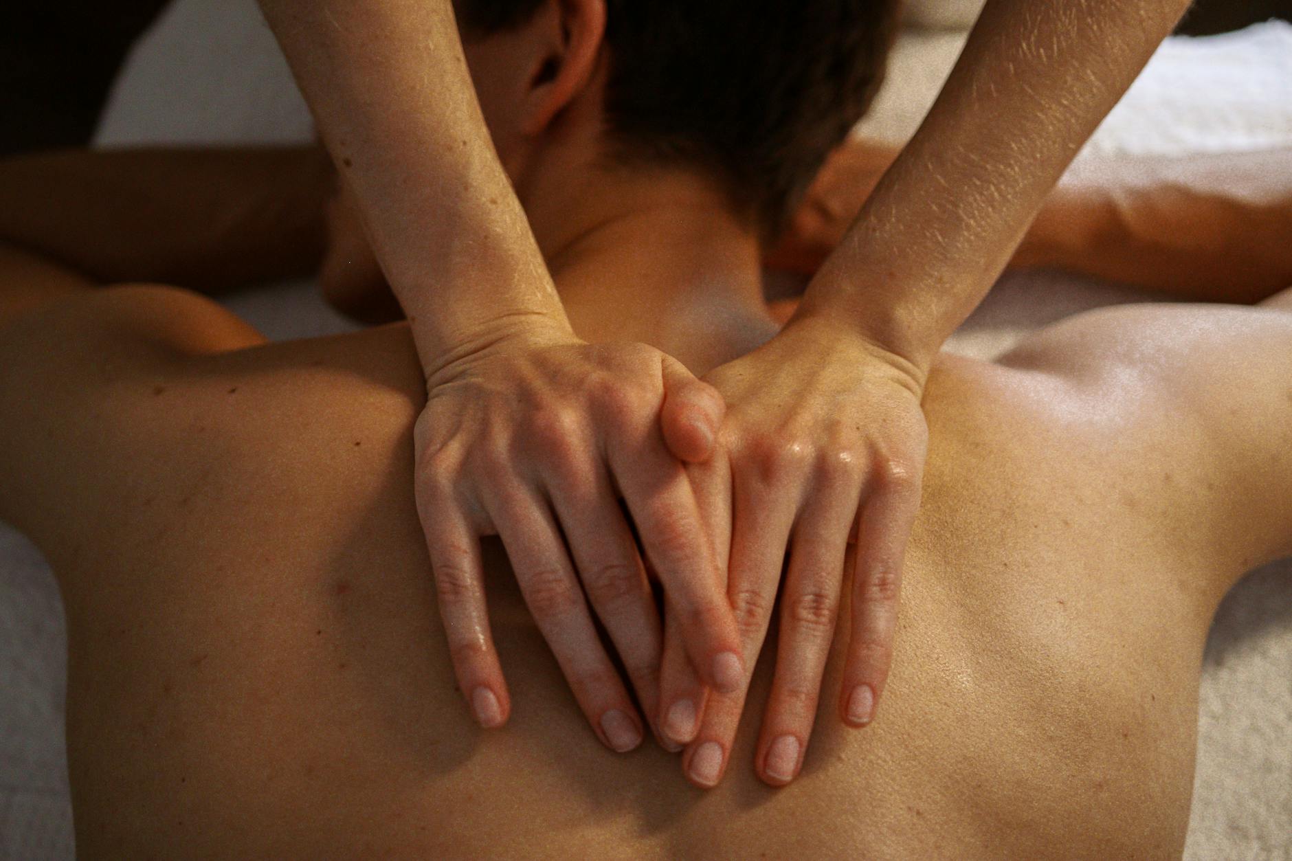 Professional massage therapist preparing treatment room with oils and therapeutic tools