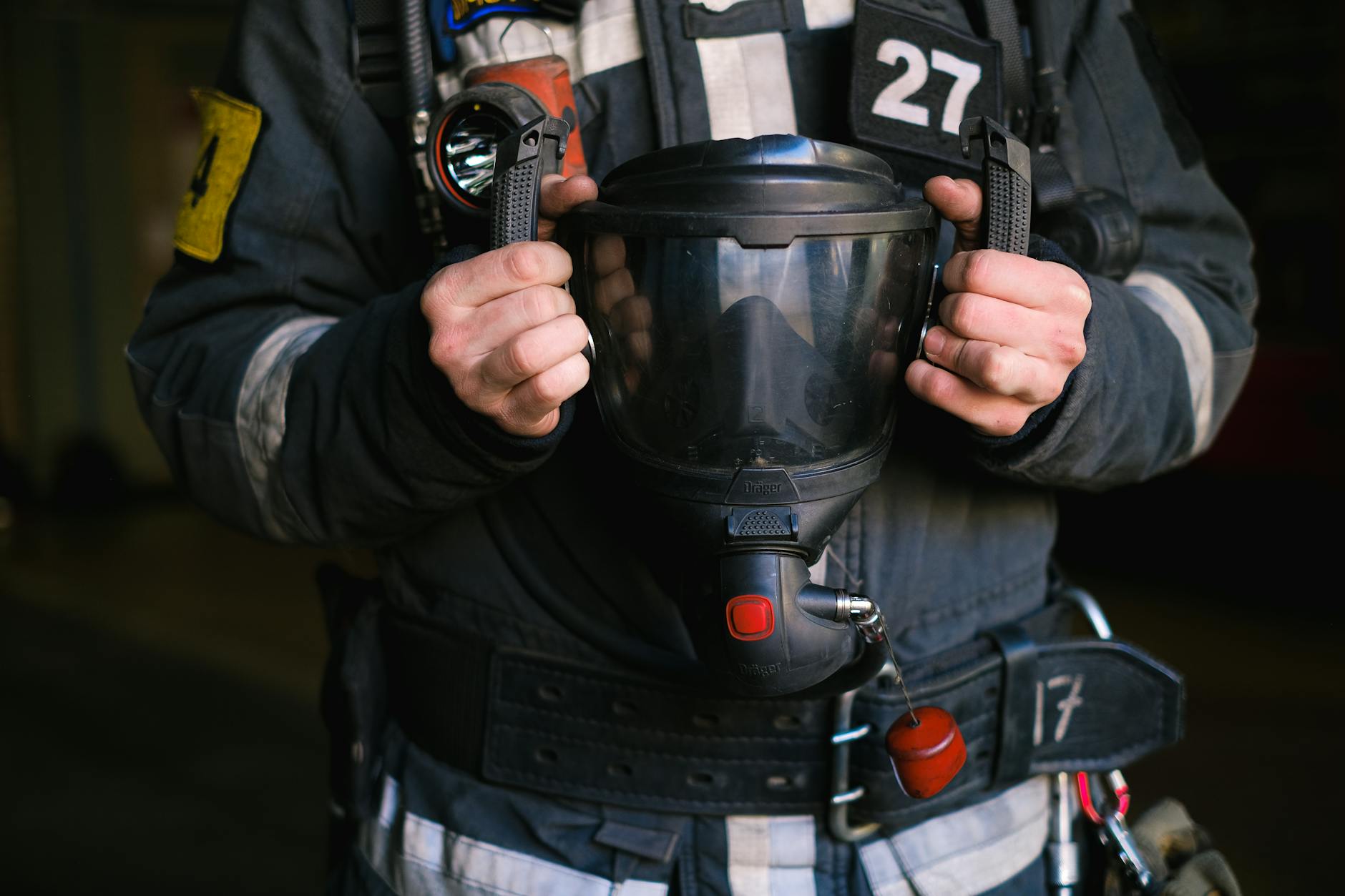 Professional firefighter protective equipment and gear laid out displaying reflective strips and utility features