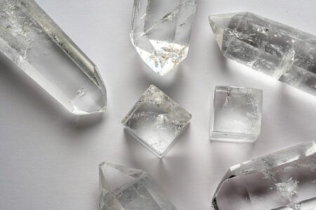 Collection of healing crystals including rose quartz and amethyst arranged on white surface