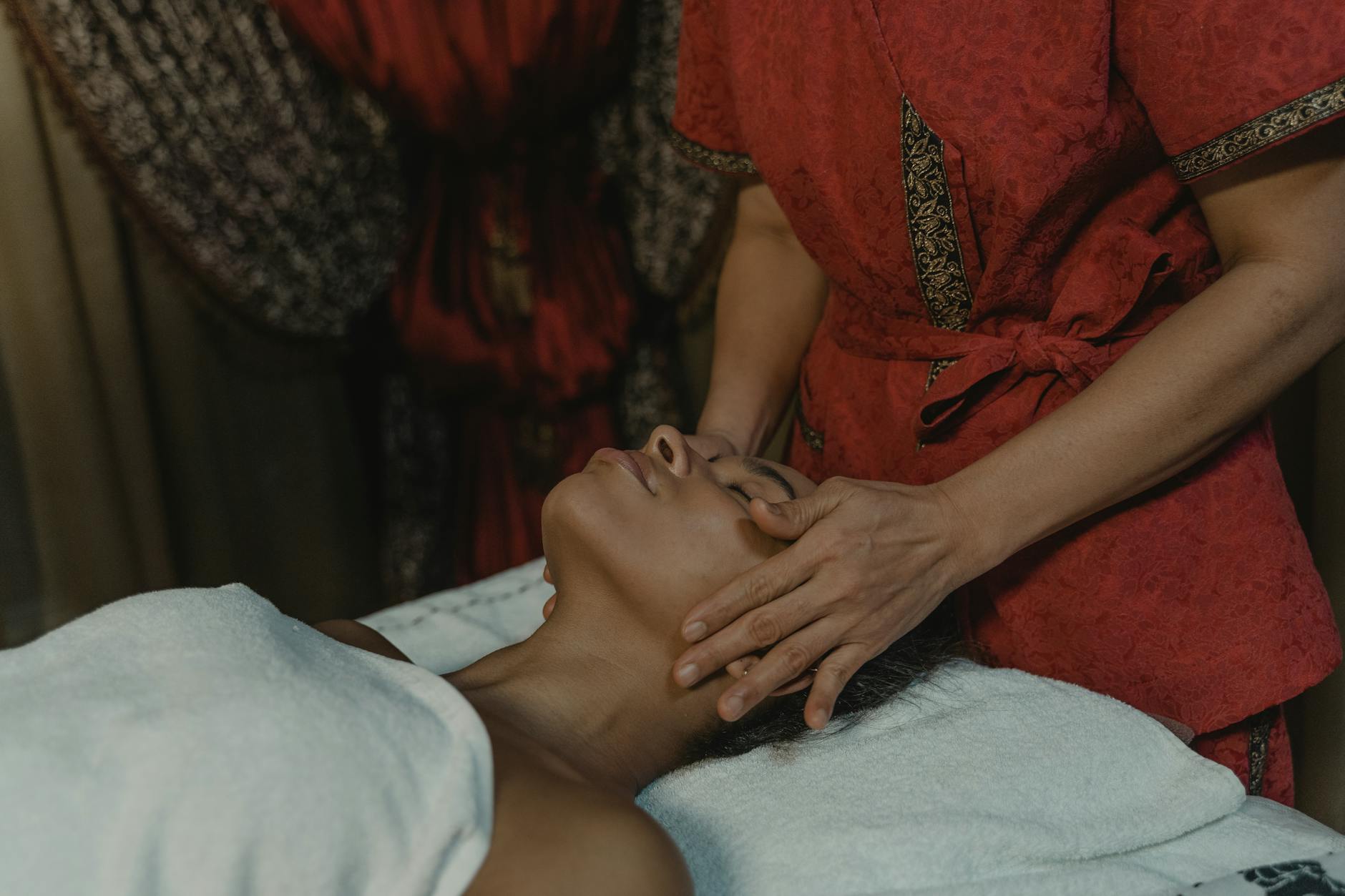Professional esthetician performing gentle facial massage on client in spa setting