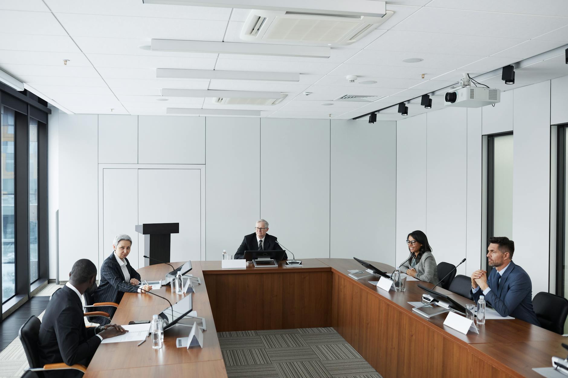Professional business meeting with executives in simple, minimalist clothing discussing strategy