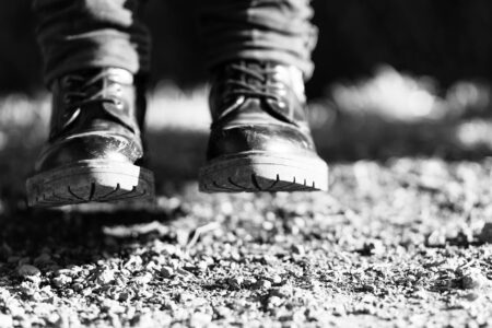 How Firefighter Boots Became Fashion Week’s Unexpected Footwear Trend Close-up of black utility boots worn with fashionable clothing on urban street