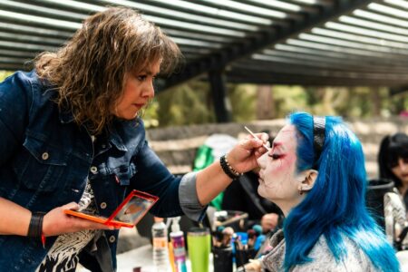 Professional makeup artist applying cosmetics with various beauty products and brushes