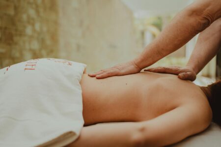 Professional spa massage therapist performing gentle facial treatment on client