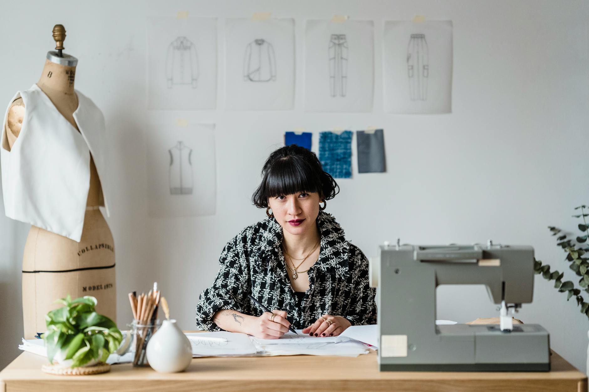 Modern fashion design studio with fabric samples and sketches on work tables