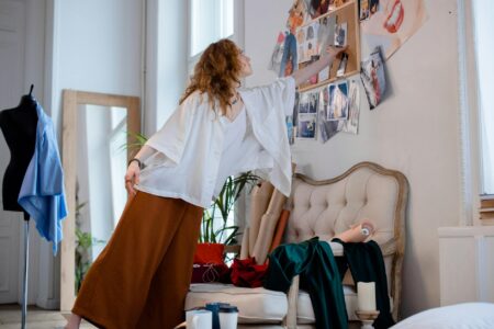 Fashion design student working at table with fabric samples and sketches
