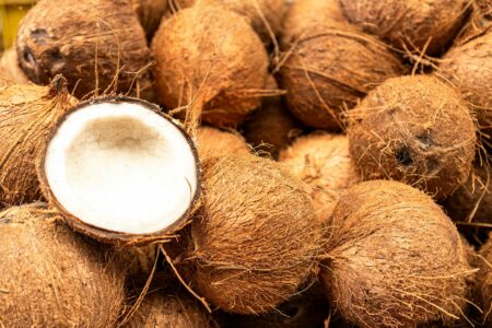 Glass jar of coconut oil with wooden spoon for oil pulling practice
