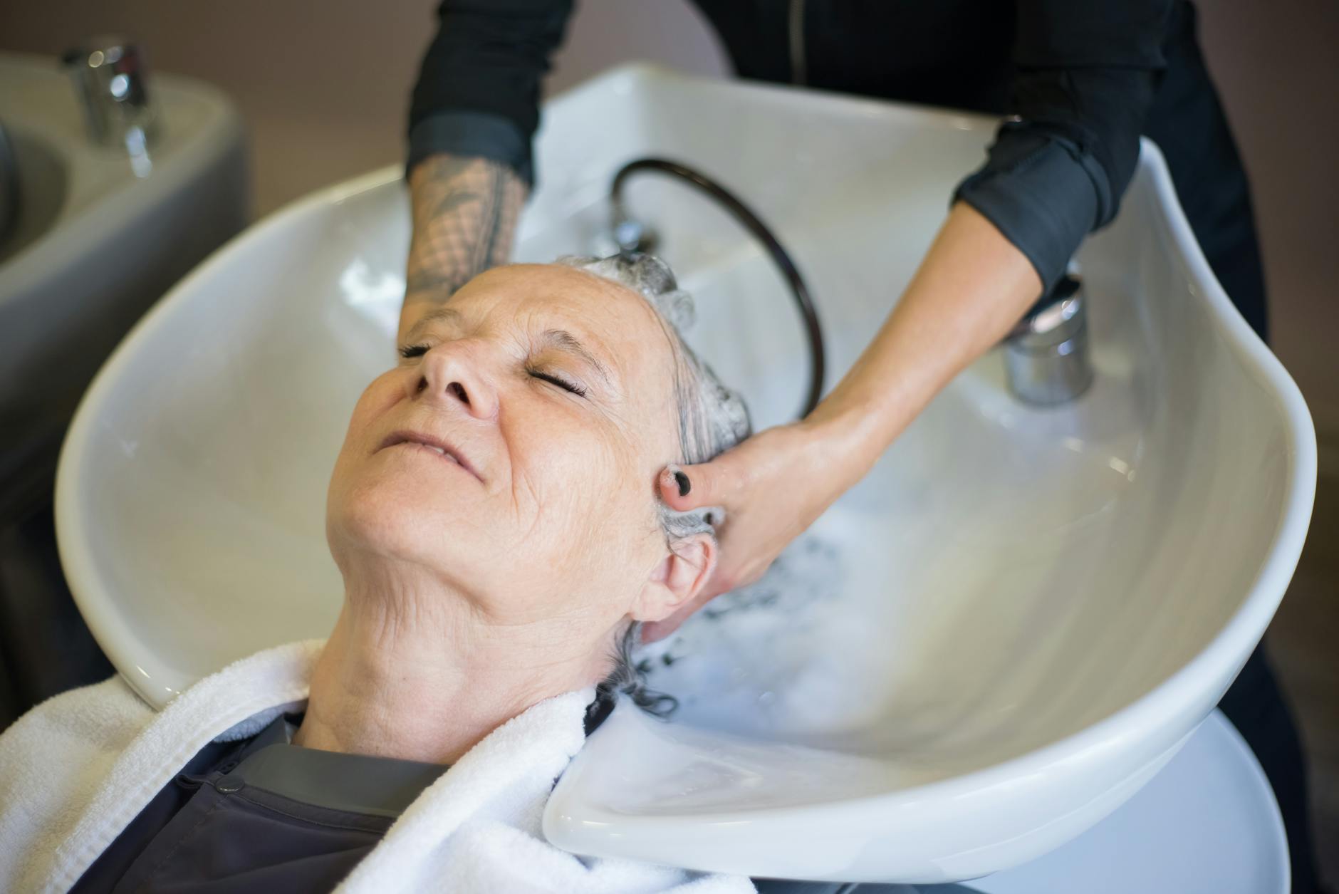 Close-up of hands performing scalp massage technique with professional massage tool