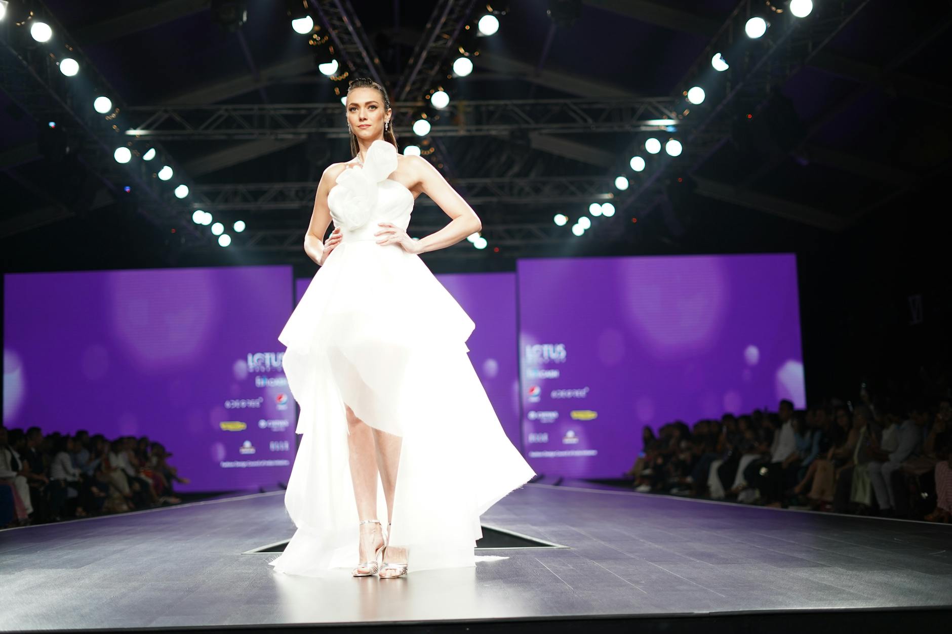 Fashion models walking runway showcasing contemporary designer accessories and structured bags