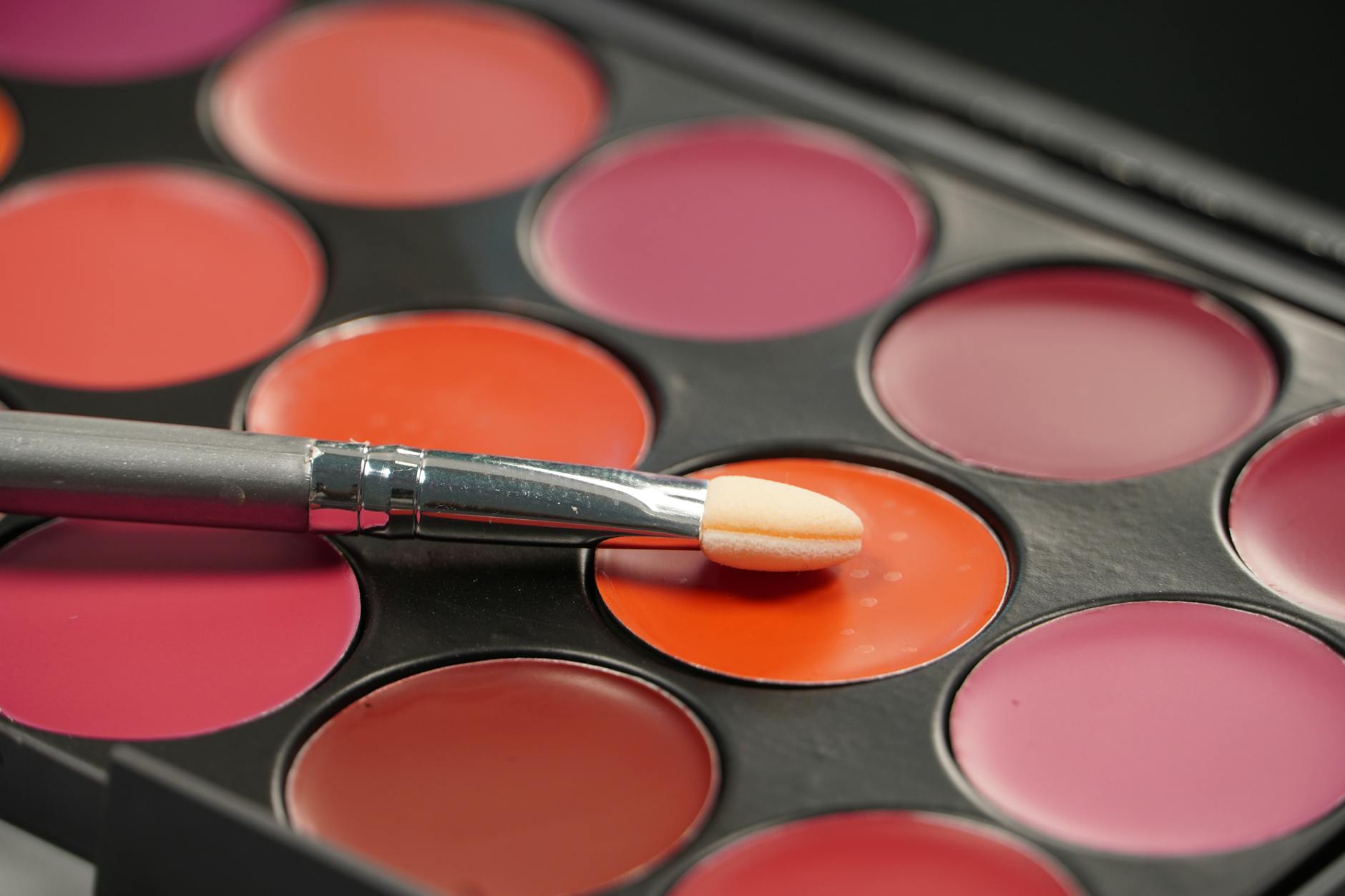 Colorful makeup palette with multiple eyeshadow shades and professional brushes