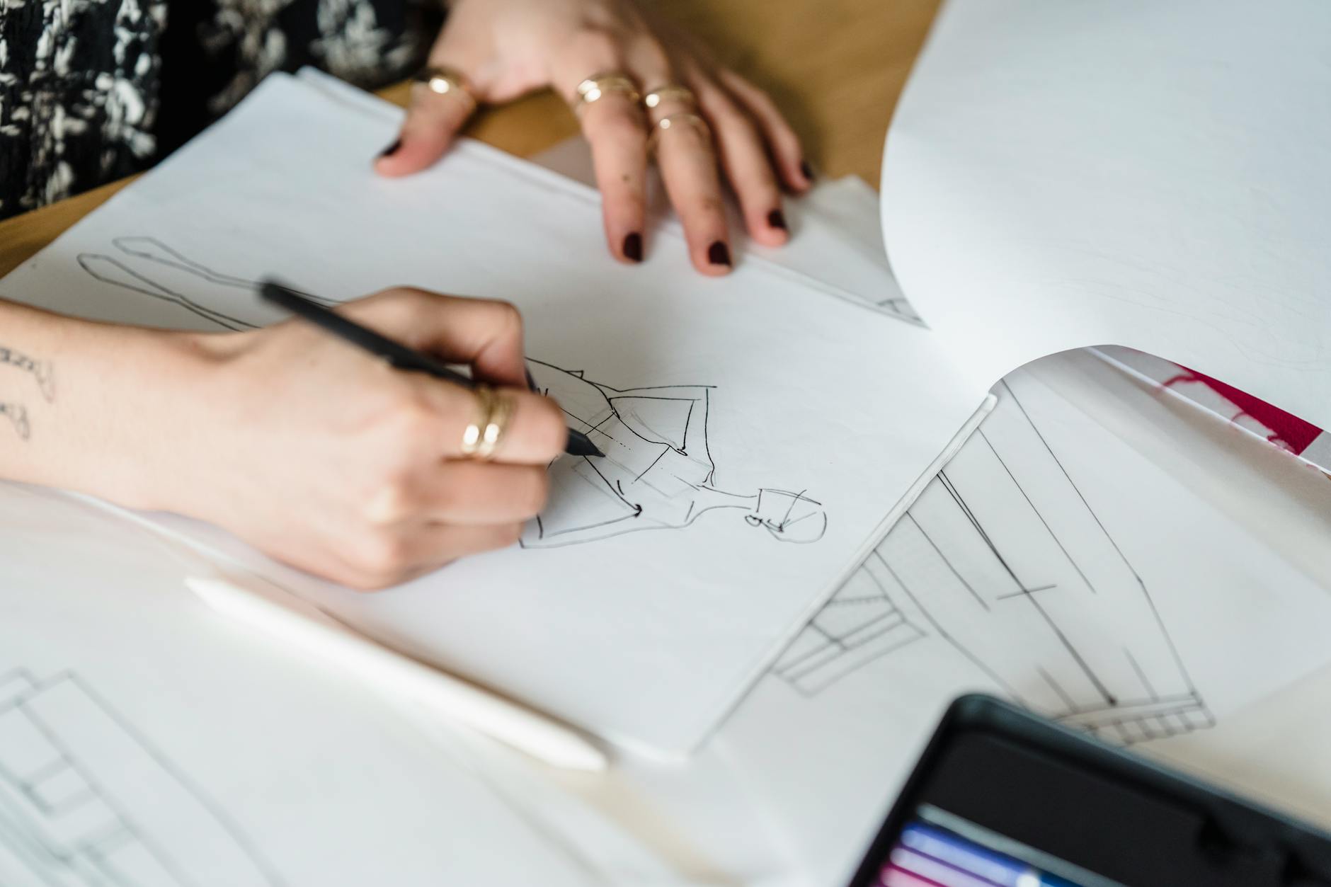 Fashion designer working at desk with fabric samples and sketches