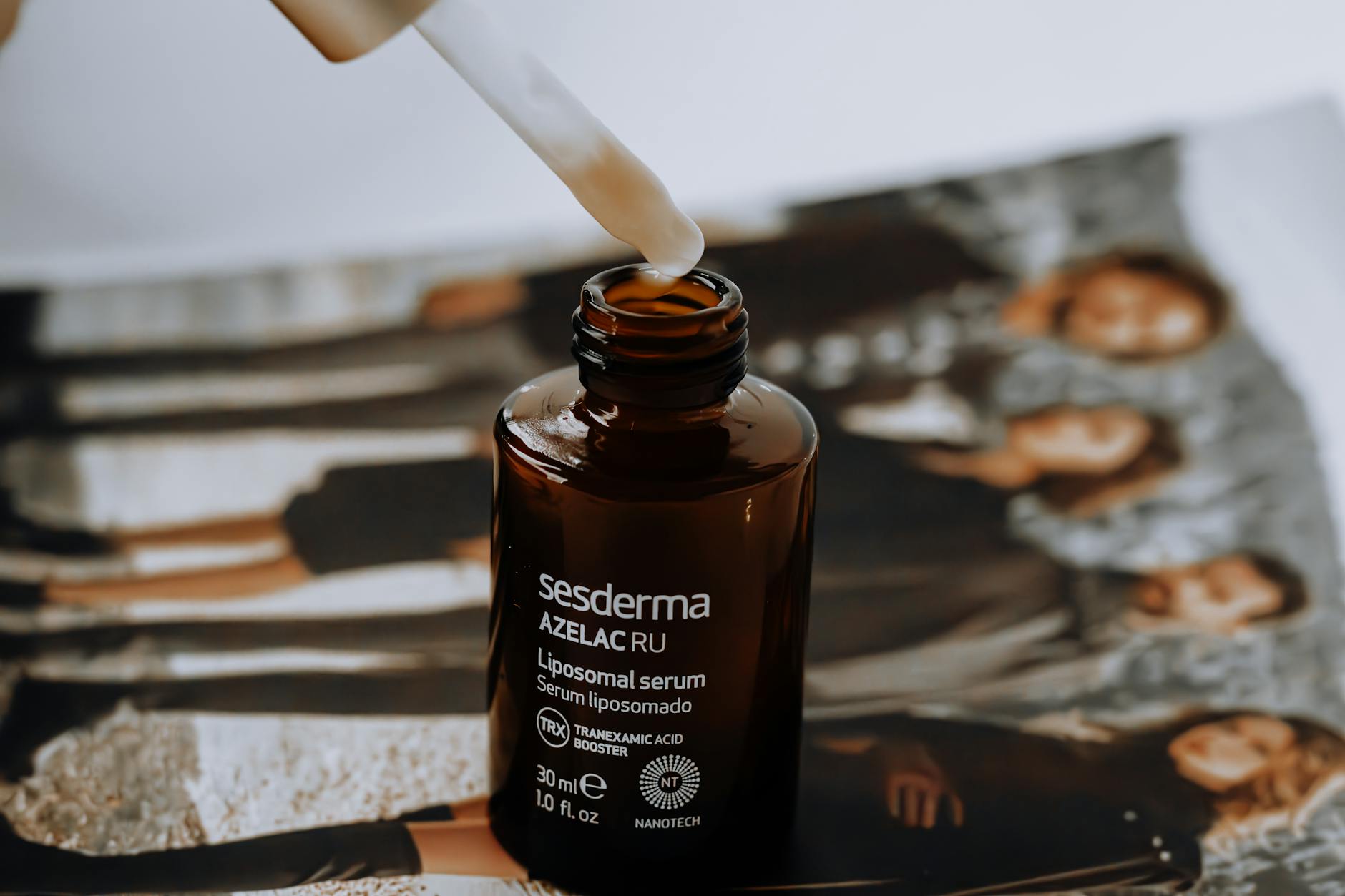 Glass dropper bottle with amber serum on clean white background representing modern skincare formulations