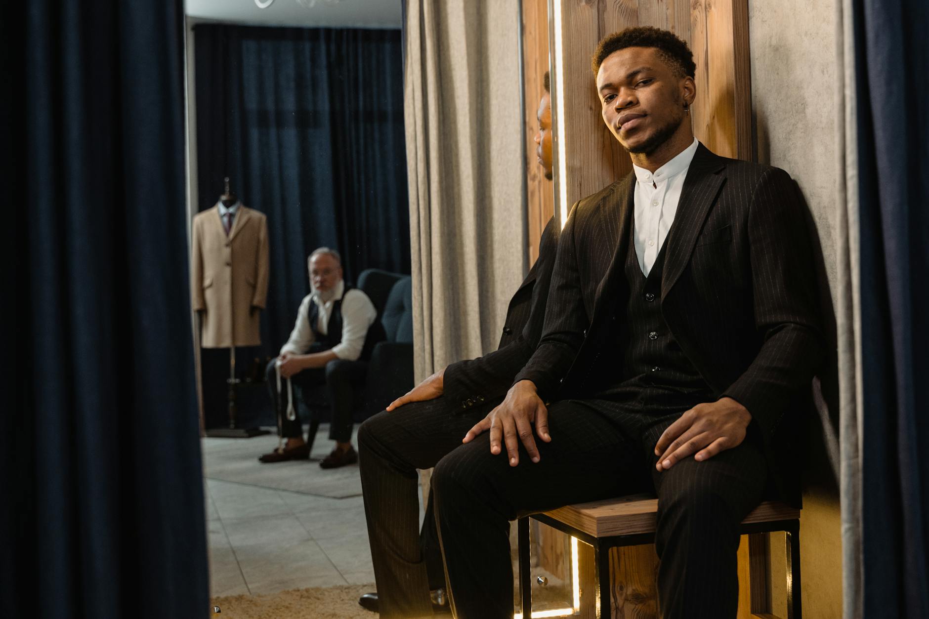 Professional tailor measuring and fitting a custom luxury suit on a client