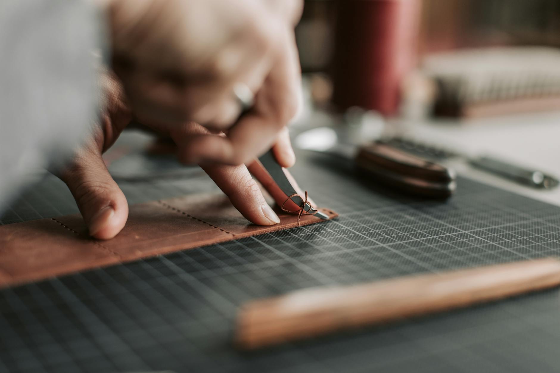 Skilled hands working on leather craftsmanship project with precision tools