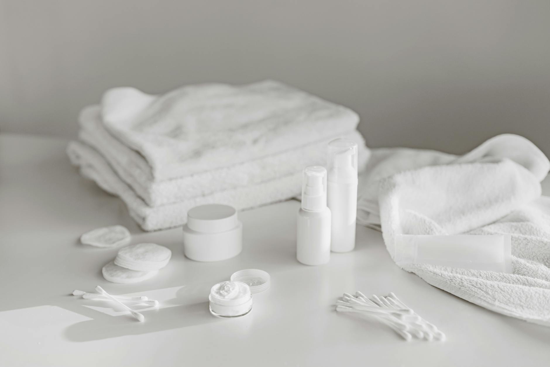 Various skincare bottles and containers arranged on marble surface