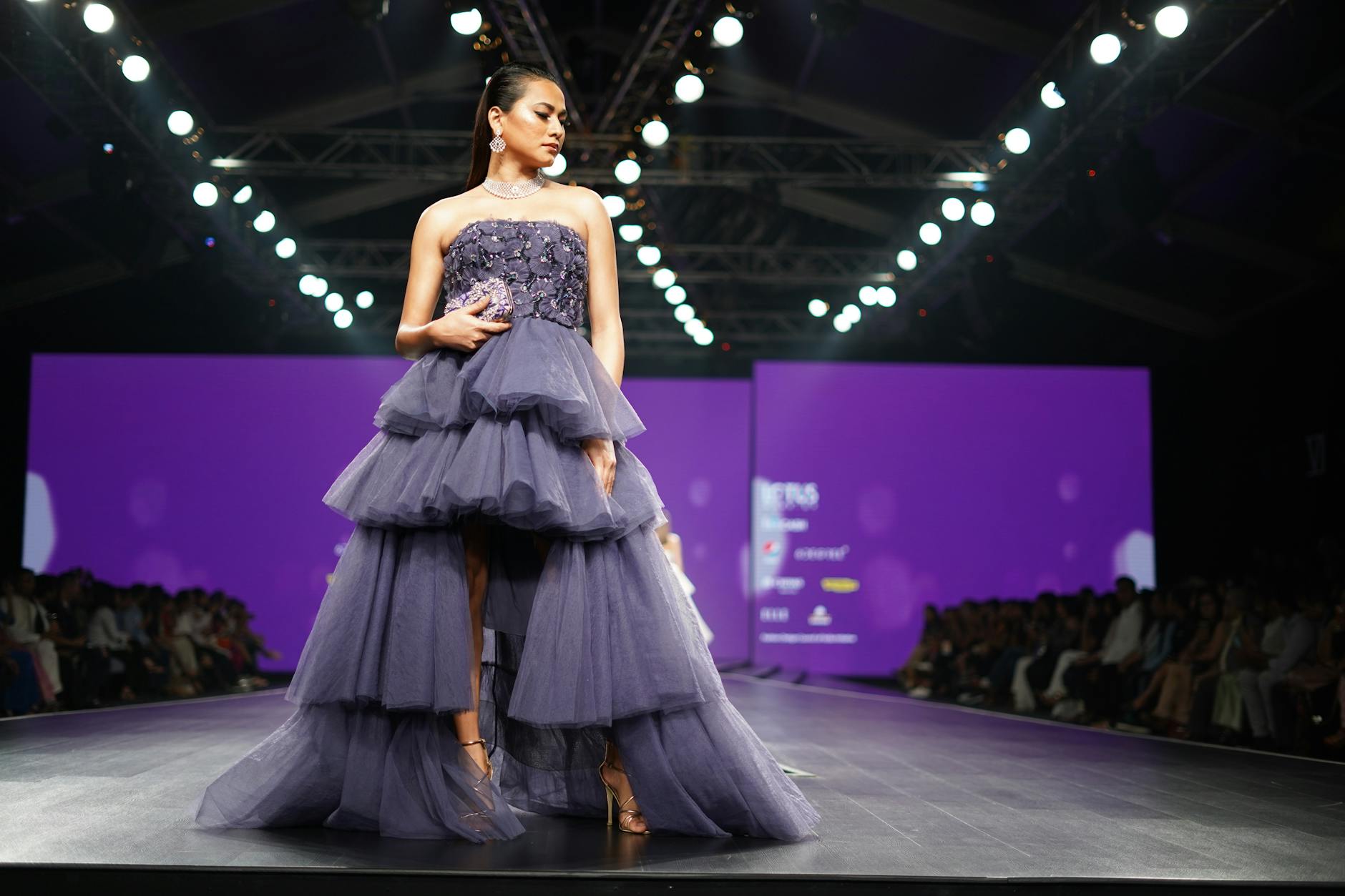 Models walking on fashion runway during luxury fashion show, displaying contemporary haute couture styling