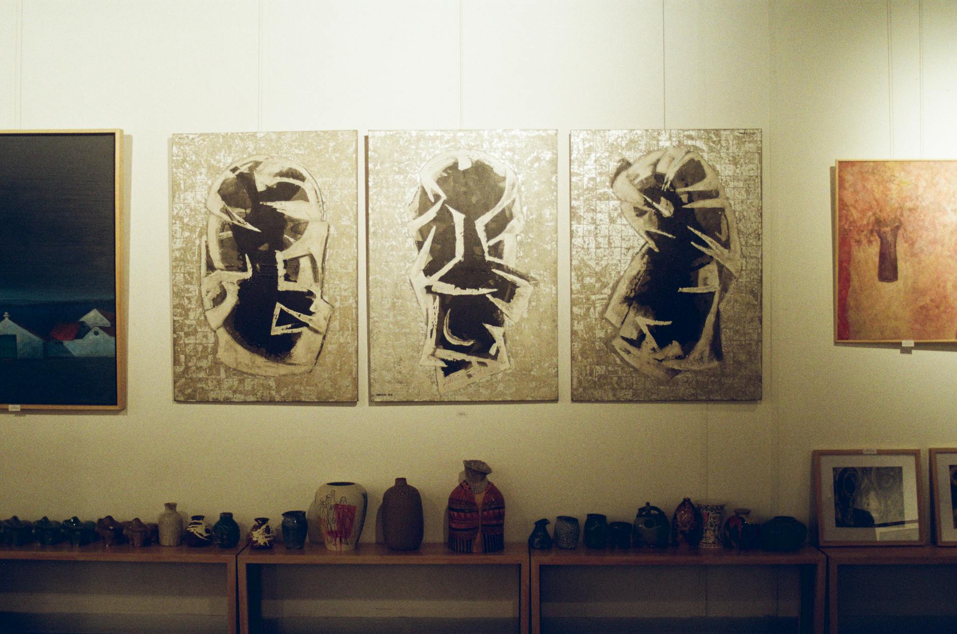 People viewing artwork at contemporary art exhibition with museum staff member visible