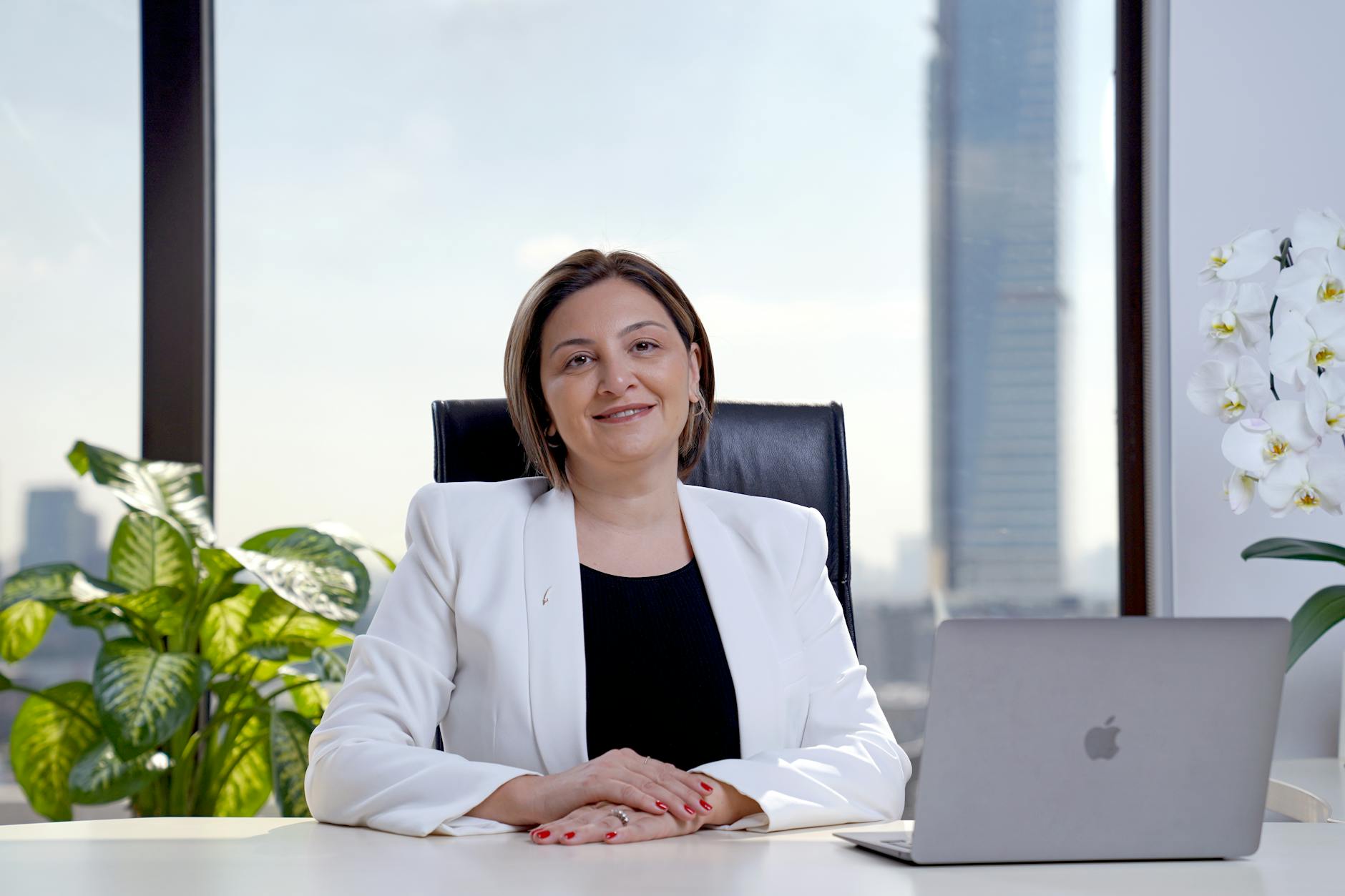 Executive in simple, understated business attire working at modern office desk
