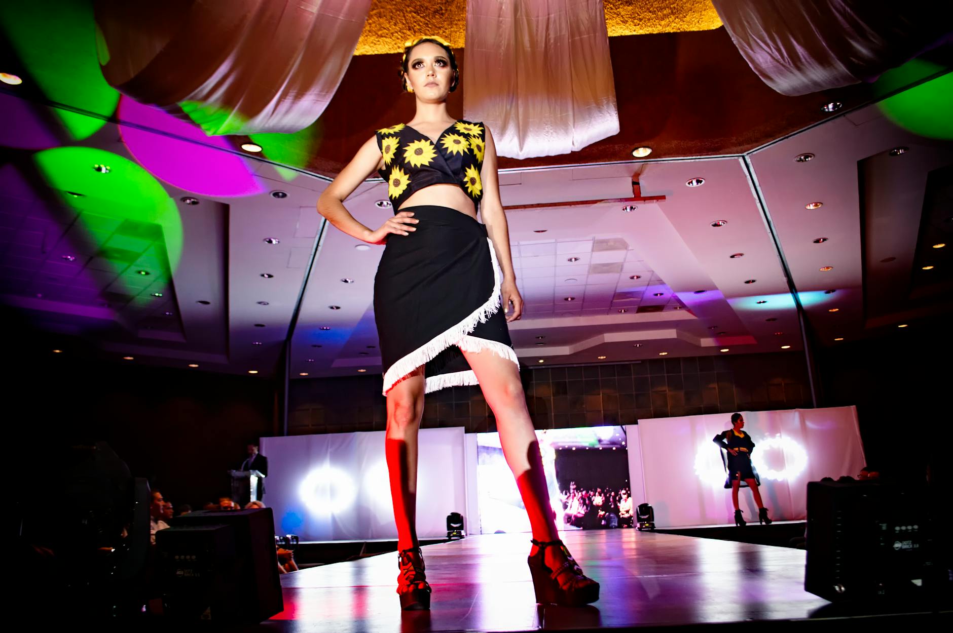 Fashion models on runway showcasing contemporary designs with visible mending elements