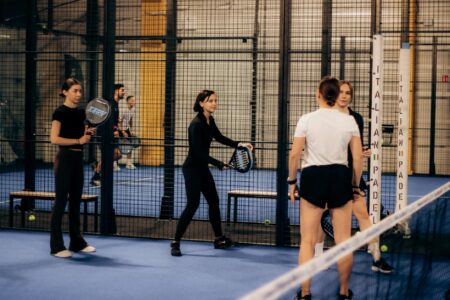 Padel Court Style Is Quietly Eclipsing Tennis’s Dress Code Players on a glass-walled padel court wearing casual athletic clothing