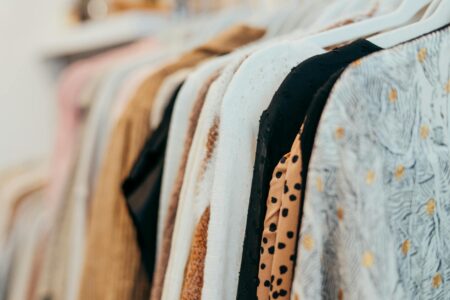 Vintage Carhartt Workwear Is Selling for Designer Prices on Resale Apps Vintage clothing hanging on rack showing worn jackets and workwear
