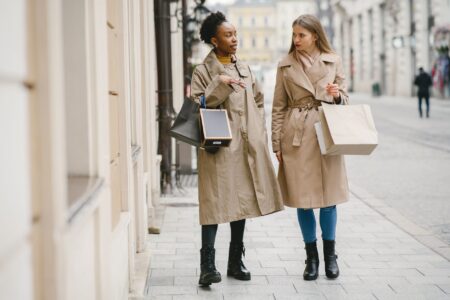 Model wearing a structured wrap coat with wide lapels and belted waist in a minimal fashion setting