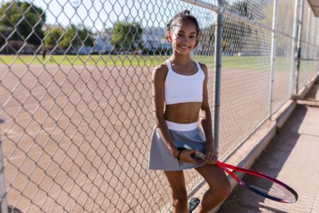 A person wearing a pleated athletic skort outdoors in casual streetwear styling