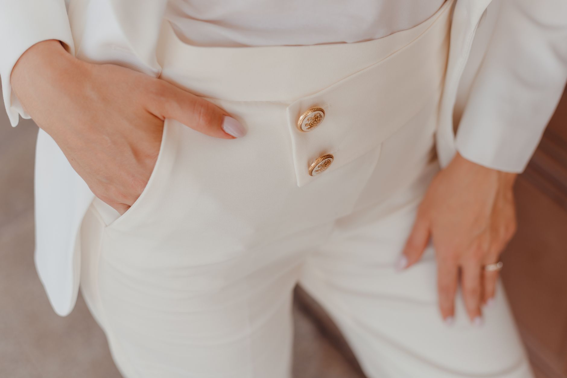 Close-up of tailored trousers with a high waist and tapered leg in neutral tones