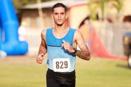 A sleeveless athletic vest with structural seaming and deep armholes laid flat on a surface
