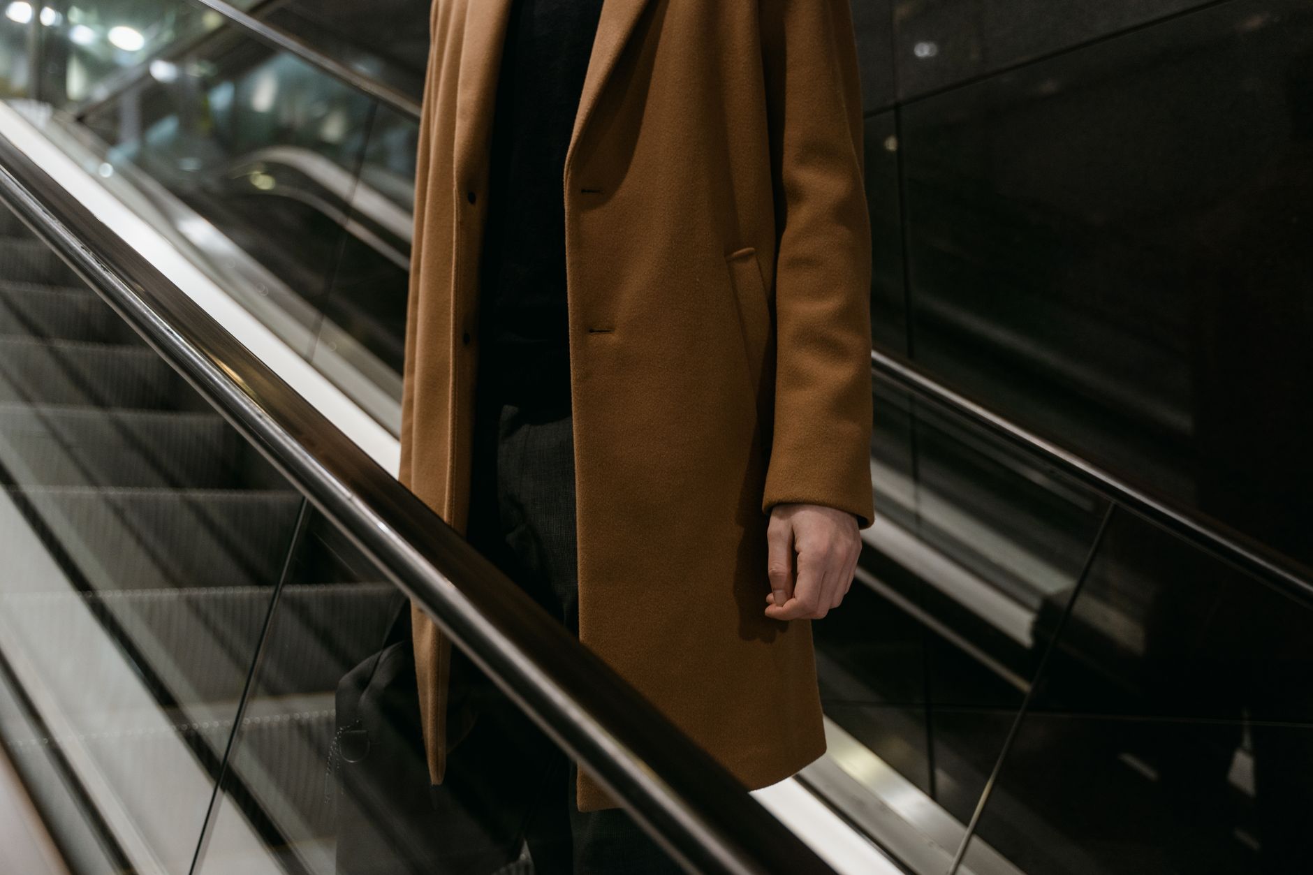 Person wearing a clean polo neck and wide-leg trousers in a minimalist outfit