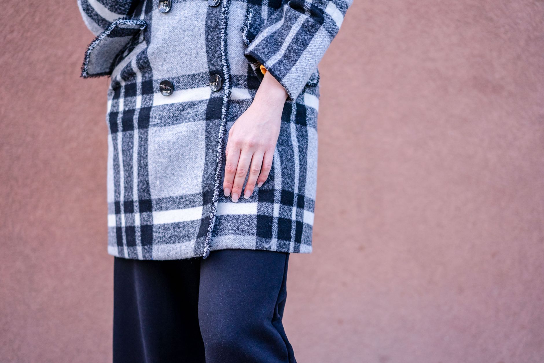 A well-layered winter outfit featuring a slim gilet over a knitwear base layer with tailored trousers