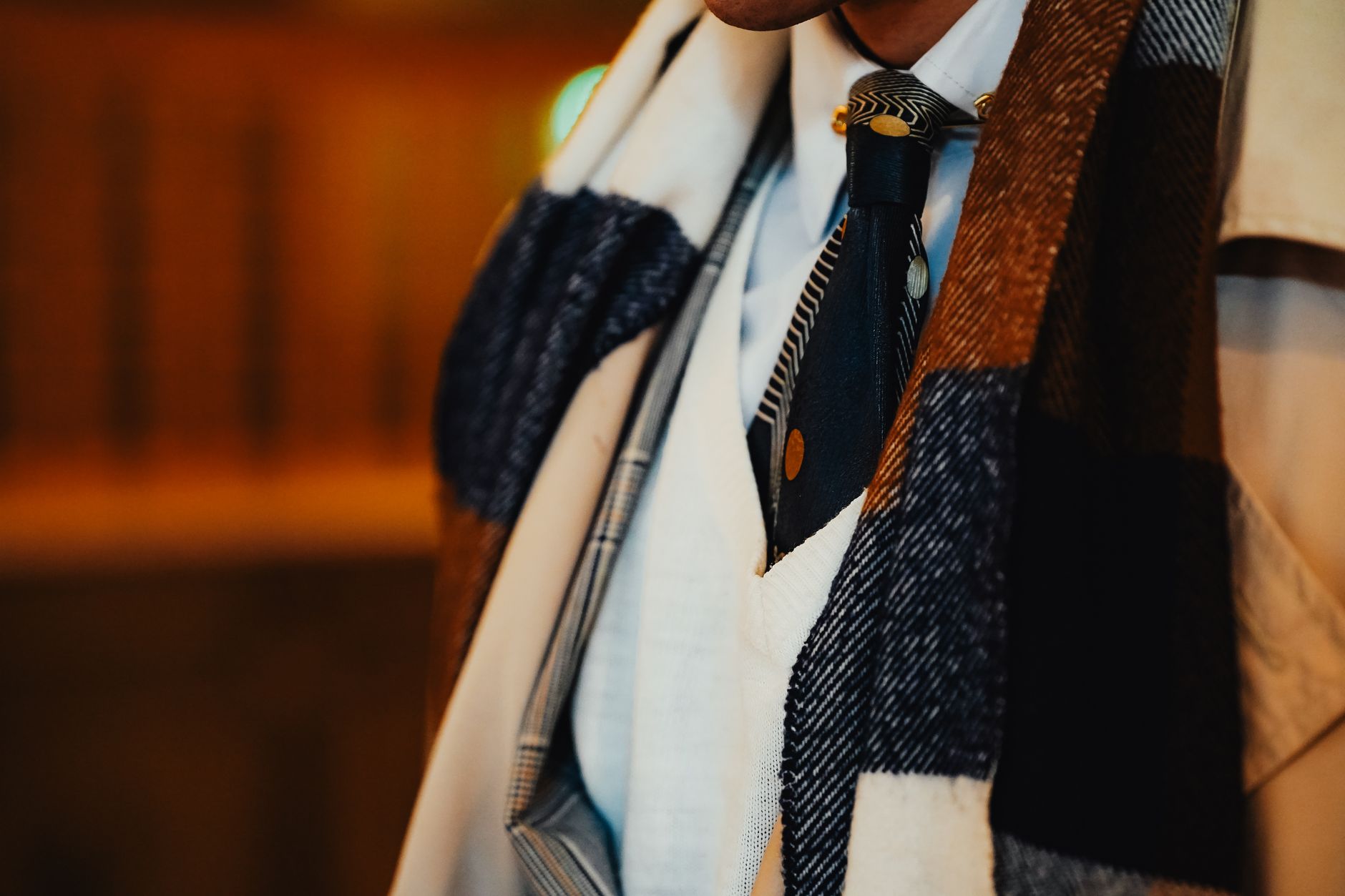 A neatly folded white stock tie laid flat, showing its structured horizontal shape and simple bar pin