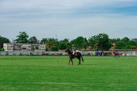 Polo players on a field wearing numbered bibs, the equestrian source reference for graphic outerwear