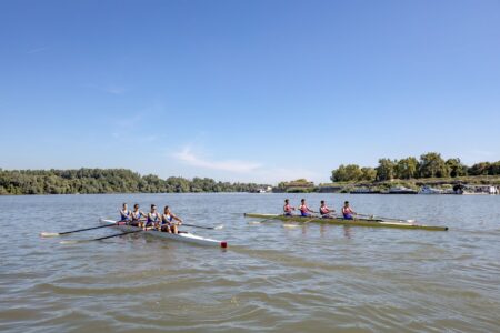 Rowing team on a river in fitted athletic leggings during training