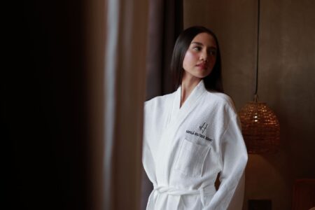 A structured long robe with wide lapel collar laid flat on a surface, showing fabric weight and clean tailoring