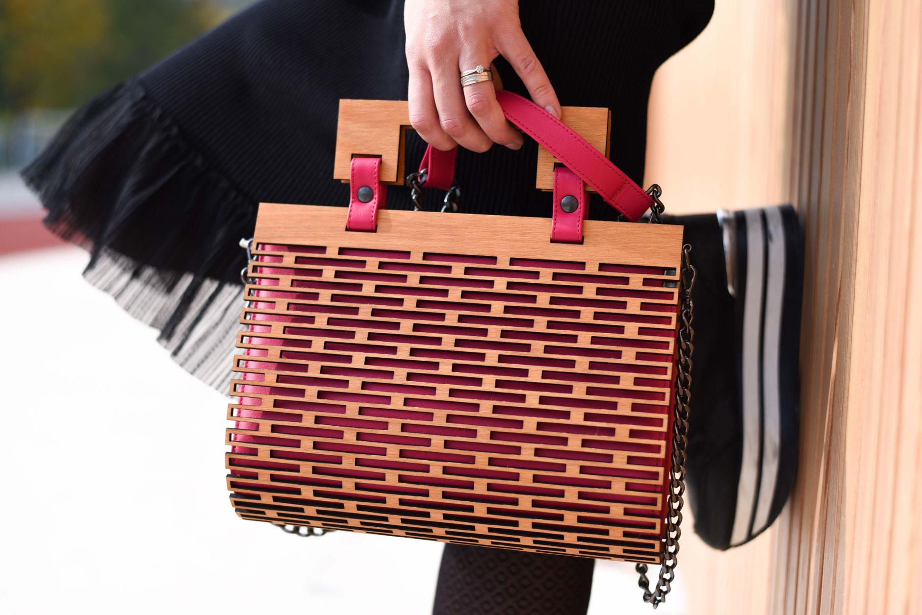 A structured leather handbag with a rigid oval opening frame on a neutral background