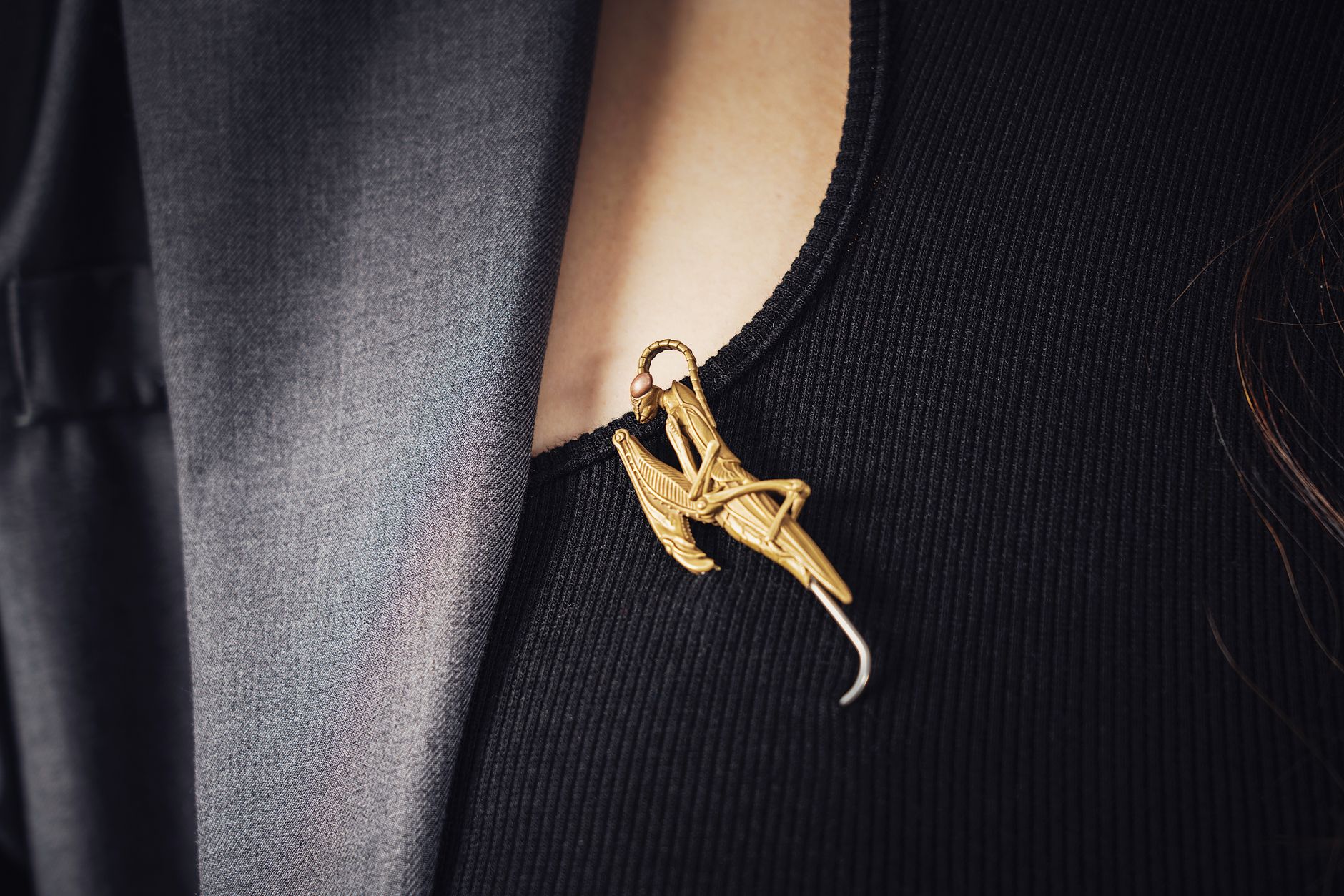 Close-up of a decorative brooch pinned to the lapel of a tailored navy blazer
