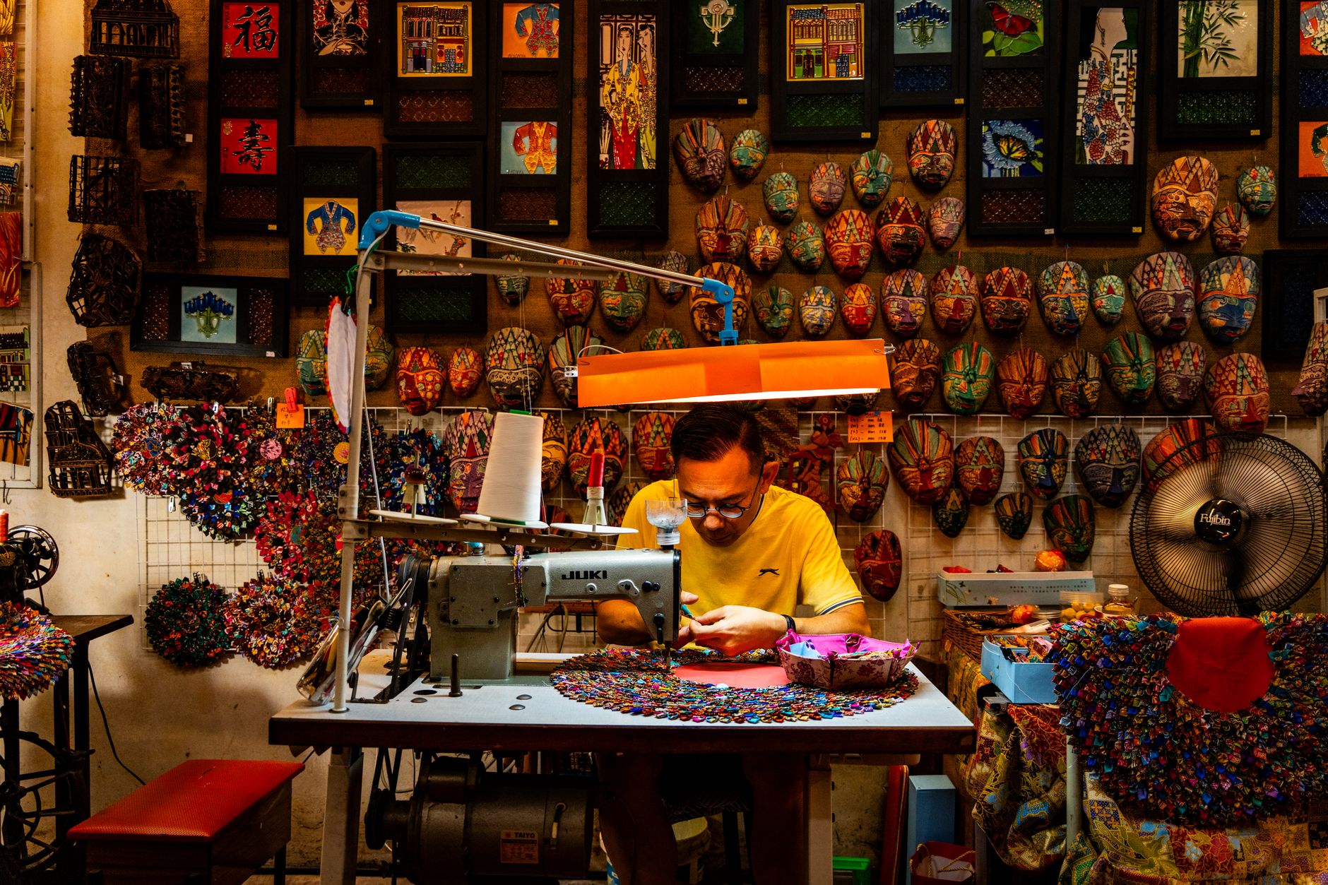 Artisan working with heavy leather material at a glove-making workbench