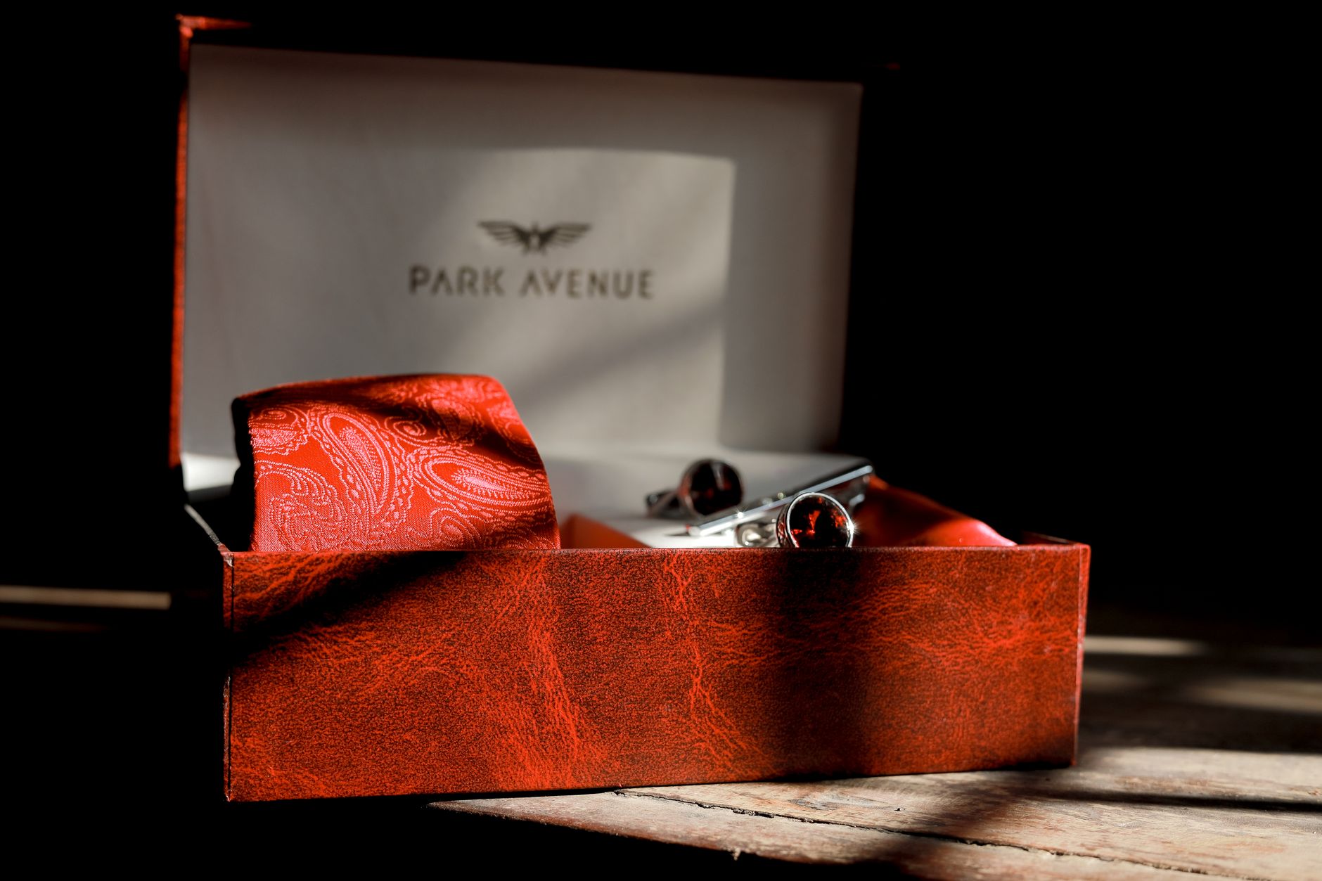 Flat lay of refined menswear accessories including leather and metal hardware details
