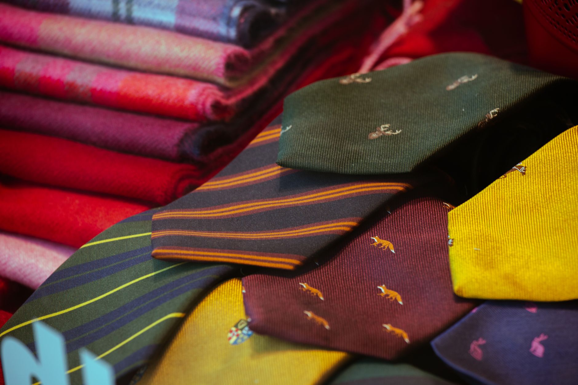 An assortment of gender-neutral neck wraps and scarves arranged on a flat lay surface