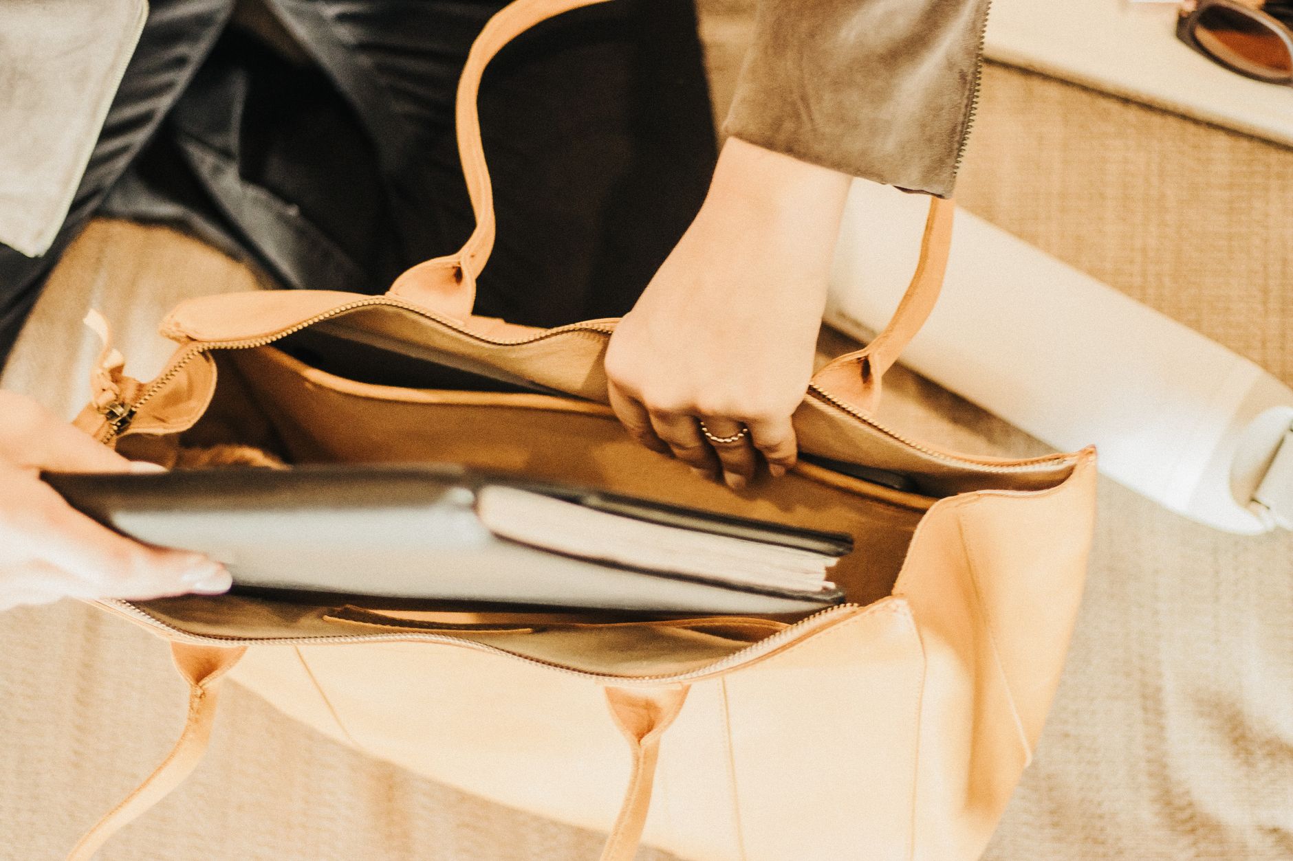 A structured tote bag with matte hardware and coated fabric exterior on a clean surface
