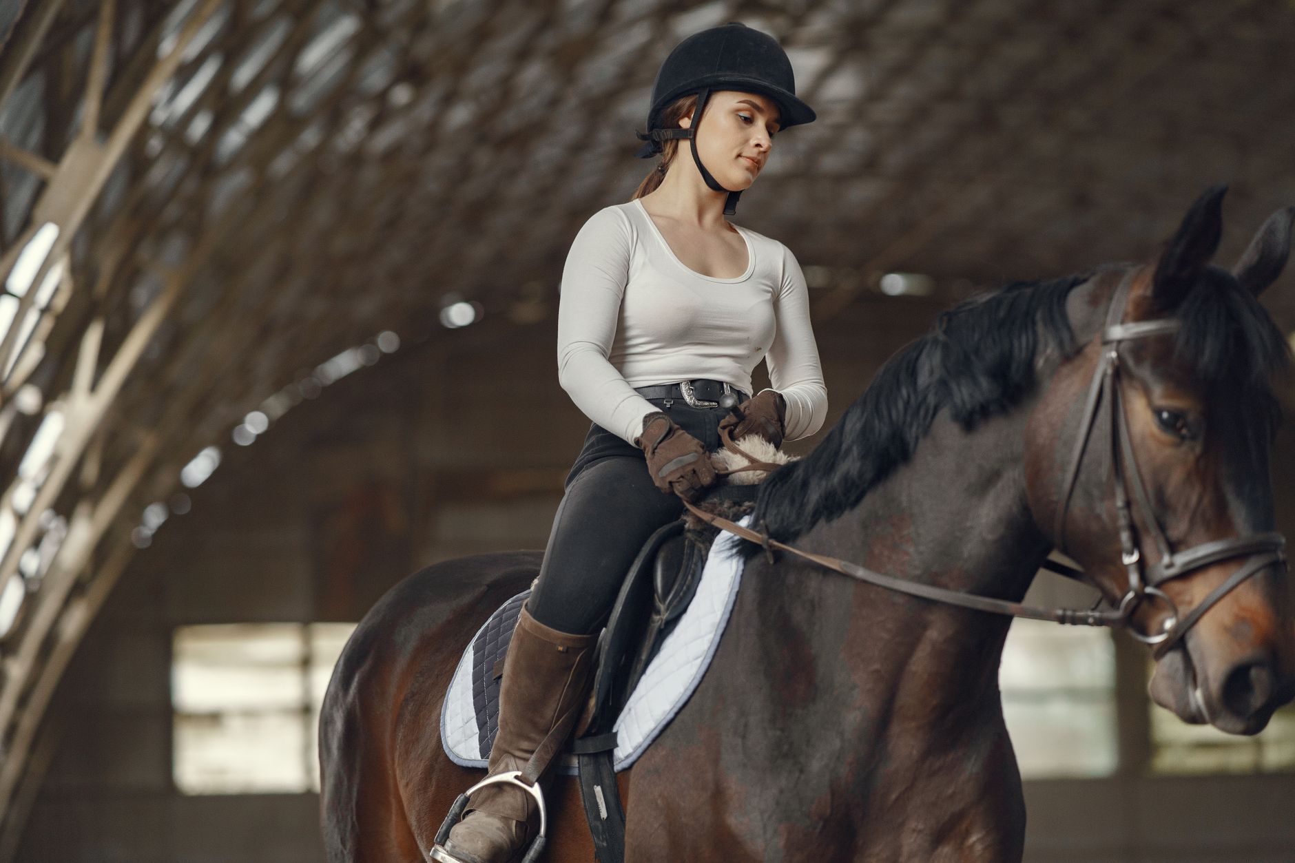 Close-up of tall riding boots paired with tailored trousers, showing equestrian-inspired street style styling
