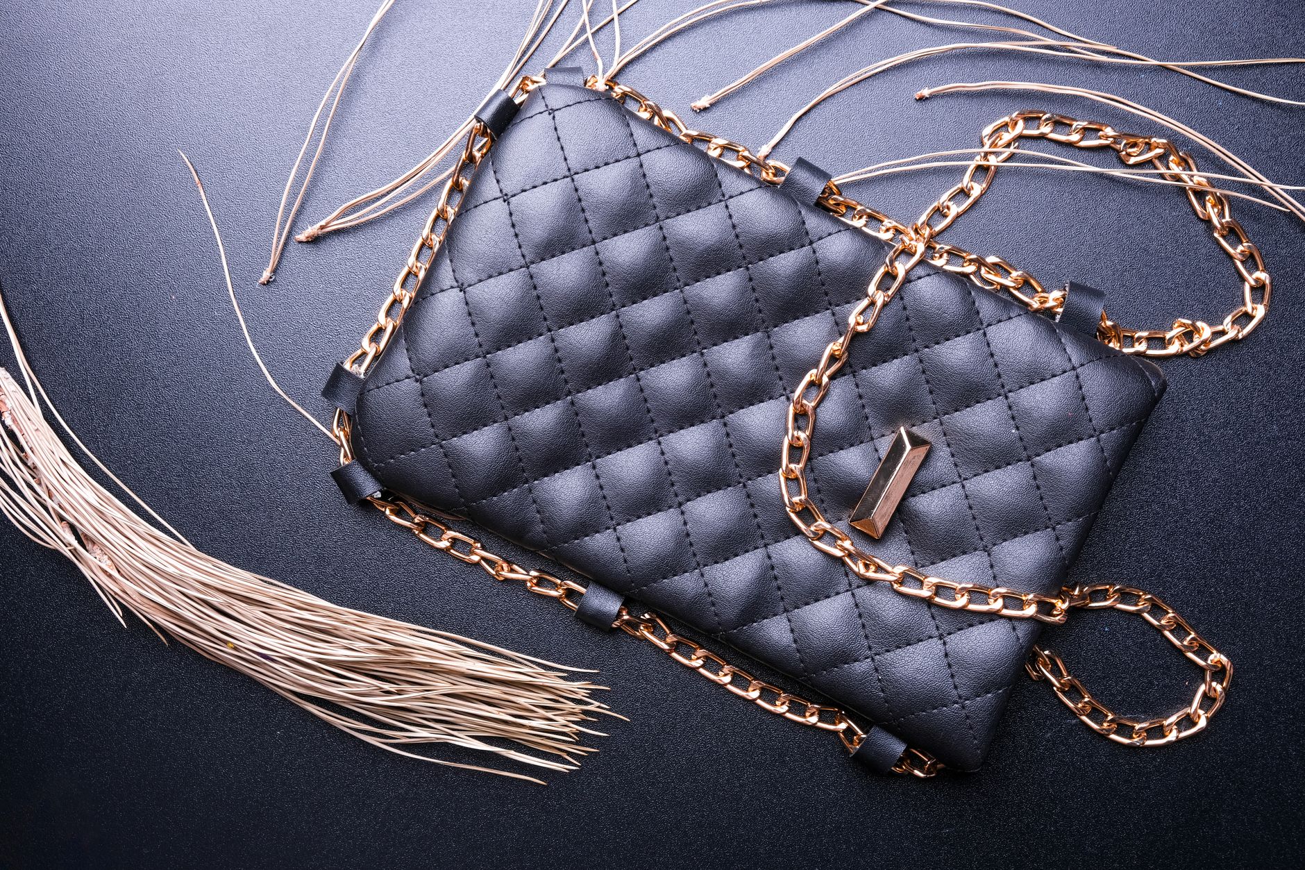 Detailed shot of a sculptural bag handle in dark resin with textured surface finish