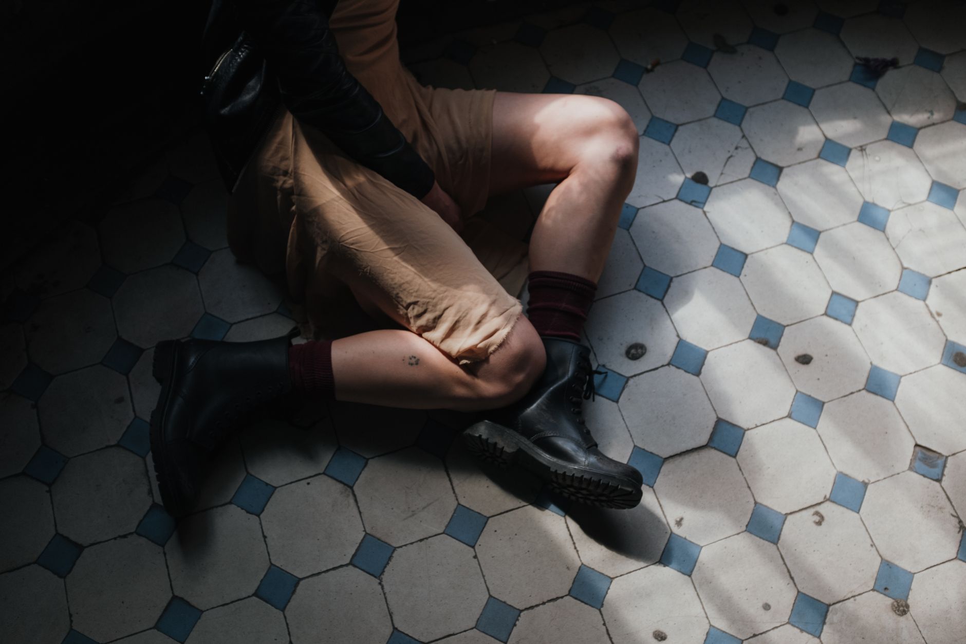 Structured leather shin piece worn over trousers as a fashion accessory