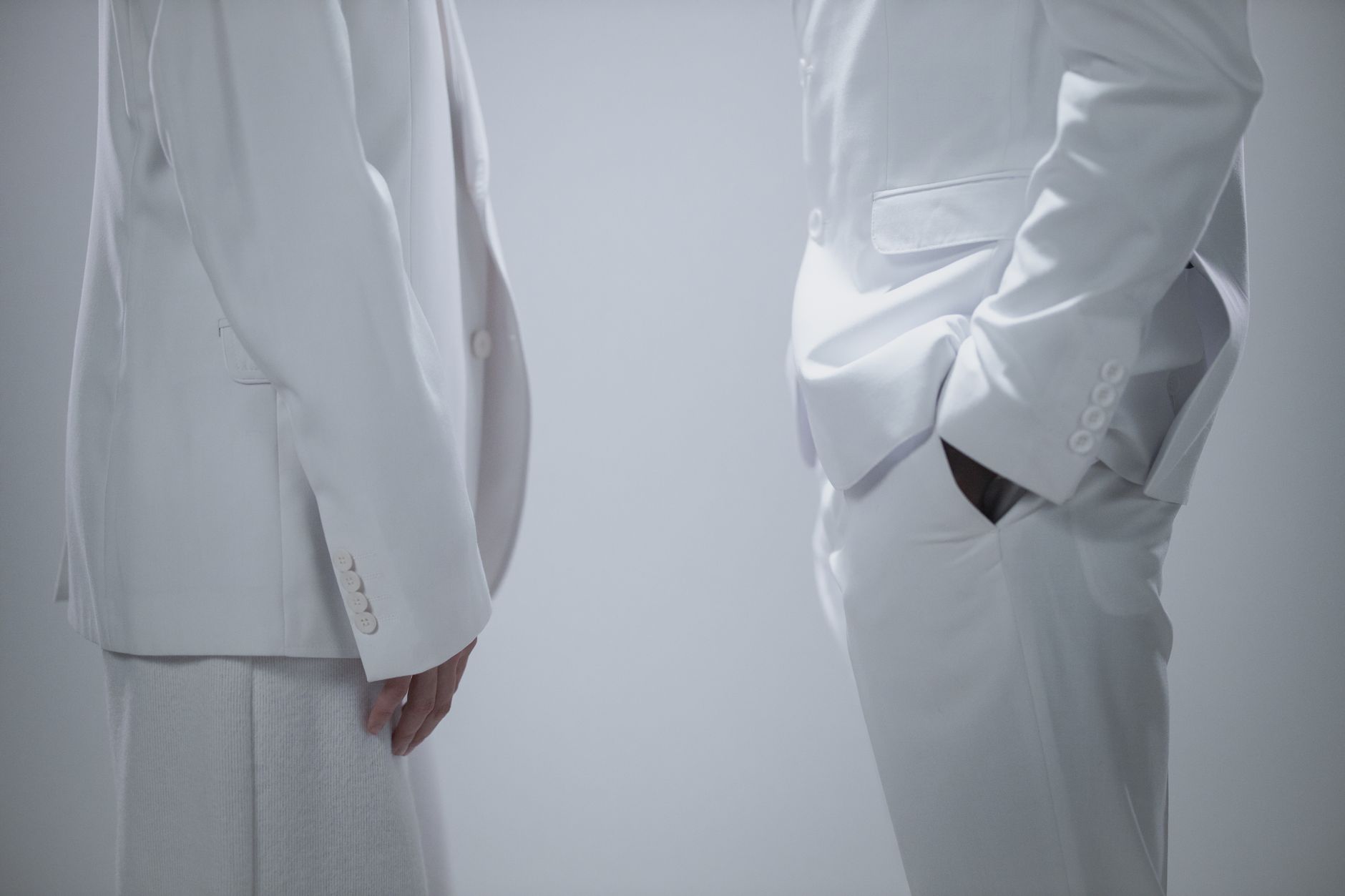 Close-up of a structured cropped jacket with peaked lapels and precise shoulder construction in a fashion editorial setting