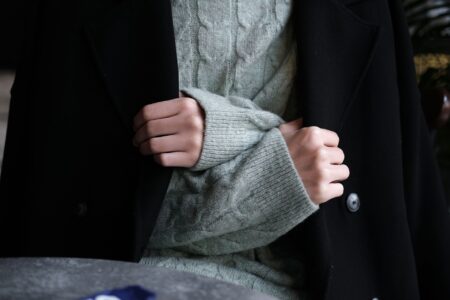 Close-up of structured tailored coat with contrast trim detail along the front facing and collar edge