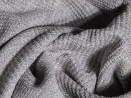 Polo Club Saddlery Wool Numnahs Are Quietly Quilting Into Outerwear Linings Close-up of quilted wool fabric with geometric stitching pattern in natural oatmeal tones